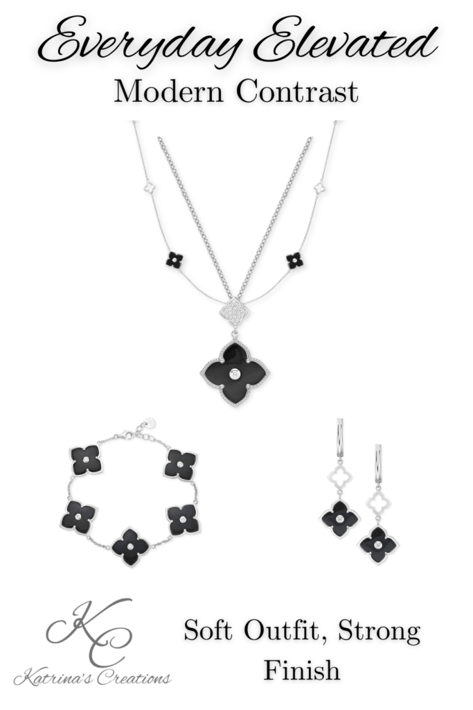 Layered silver and black floral jewelry set with statement pendant necklace, coordinating bracelet, and drop earrings displayed on a neutral background.